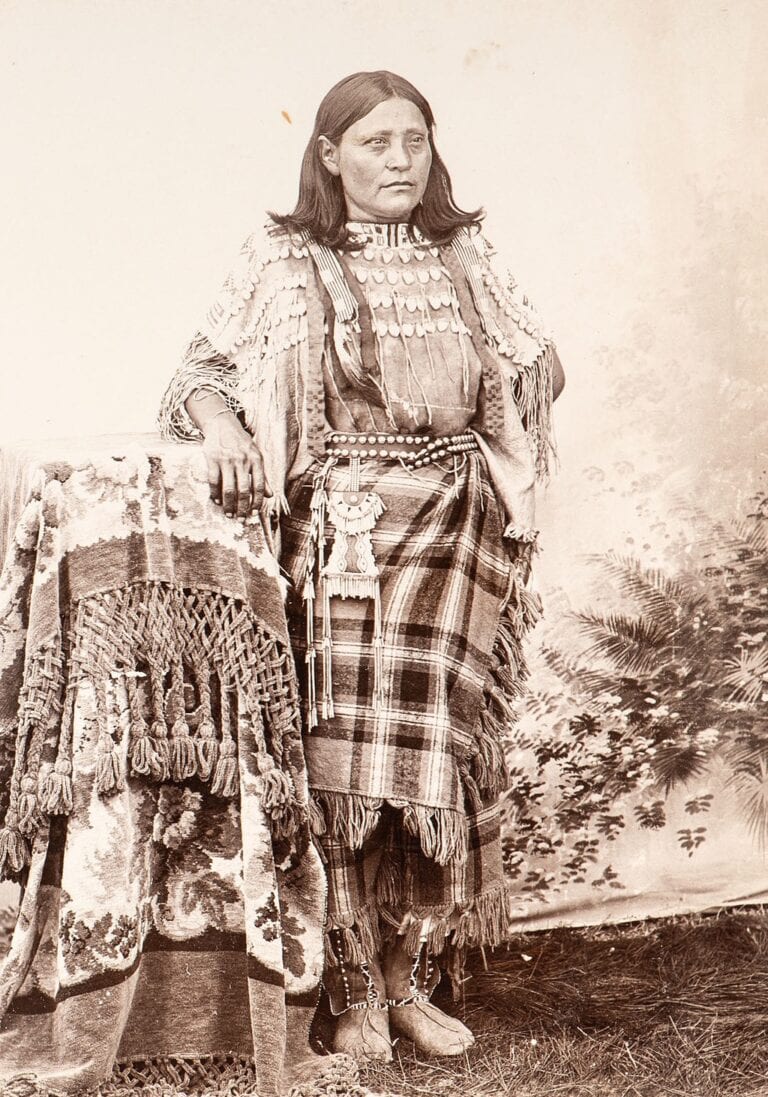 A Kiowa woman in a 19th century photograph. Her strike and light bag is attached to her belt. These bags were not only practical, but highly decorative as well.