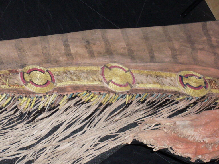 Bottom tab leggings from the Upper Missouri region. The strip is decorated with quillwork, a combination of rosettes and rectangular panels. The rosettes are embroidered with a wrapping technique, the panels with another one.