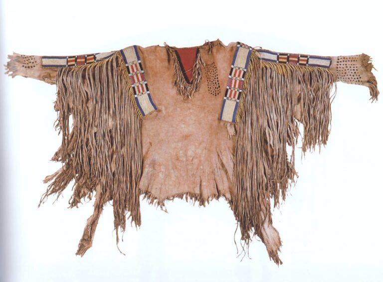 A war shirt (likely from Plateau). All four strips are embroidered using the QWHH technique and bordered with beads. NMAI.